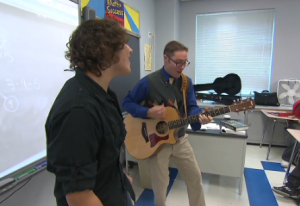 Scott Kennedy sings and teaches in from of his math class.